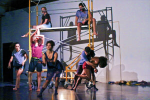 Dancers from @dance_aegis company performing among scaffolding set.
